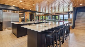 A spacious kitchen with a large island, stainless steel appliances, and a view of the outdoors.