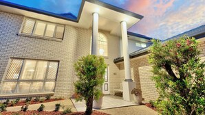 A modern house with a brick facade, large windows, and a well-maintained garden. - Holiday Inn (Parkinson)