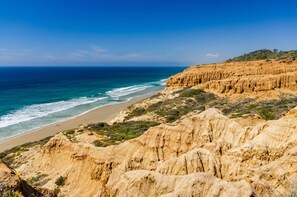 A coastal landscape with a beach, cliffs, and a clear blue sky. - The Blue Pearl - 2 minute walk to the beach! (Del Mar)