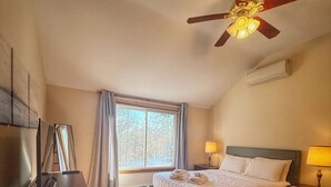 A bedroom with a bed, bedside tables, a desk, a ceiling fan, and a window with curtains. - Overlook Poolside Getaway Heated Pool (May - Oct 20th) (East Falmouth)