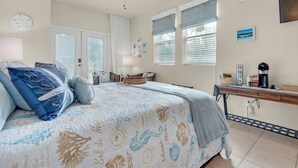 Een slaapkamer met een bed, een bureau, een stoel, een plafondventilator en een raam met jaloezieën.