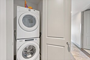 A laundry room with two stacked Whirlpool washers and dryers. - Tysons 2BR | Sunrise Views, Pool & Gym (McLean)
