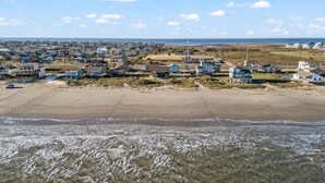 Een vogelperspectief van een kustbewoonde wijk met huizen aan het strand en een helder uitzicht op de oceaan.