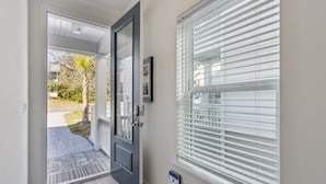 Una porta d'ingresso con un vetro, un campanello e una cassetta postale.