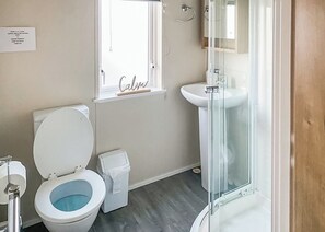 A bathroom with a toilet, bidet, and a glass shower enclosure.