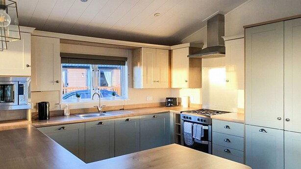 A modern kitchen with a central island, built-in appliances, and a window with a view.