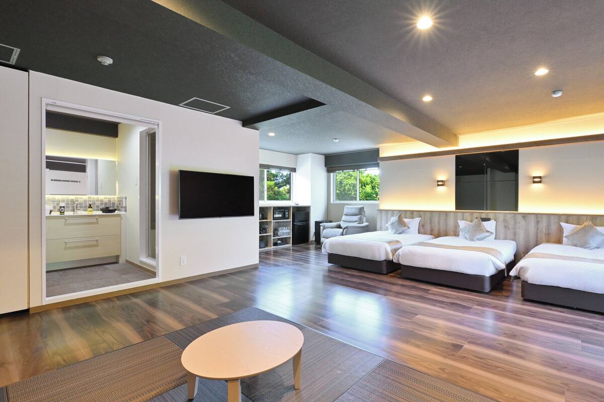 A modern hotel room with a large bed, a desk, and a TV.