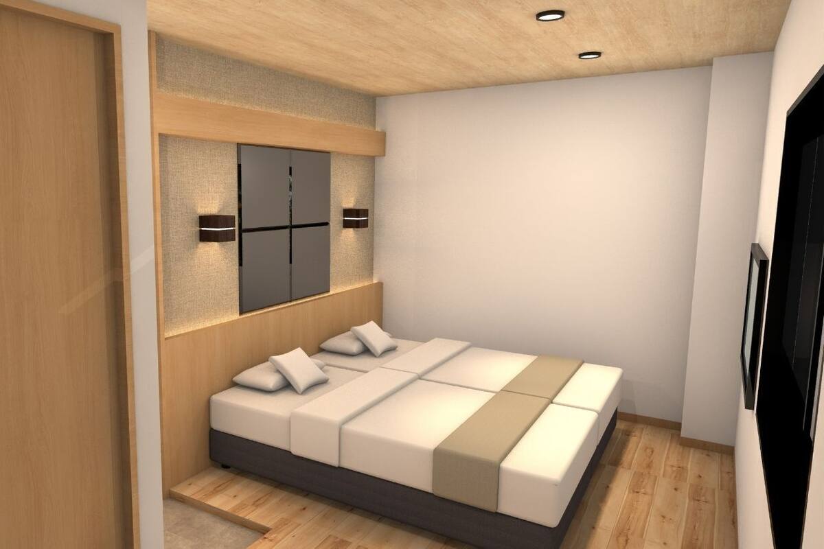 A bedroom with a bed, a wardrobe, a mirror, and a wall-mounted light.