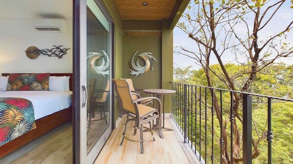 A balcony with a bed, two chairs, and a small table. - 360 Splendor 208A- Breakfast Included (360 Splendor)