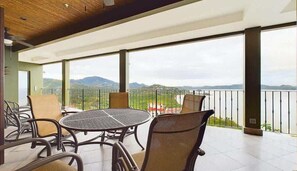 A balcony with a table and chairs, offering a view of the mountains and a body of water. - 360 Splendor 208A- Breakfast Included (360 Splendor)