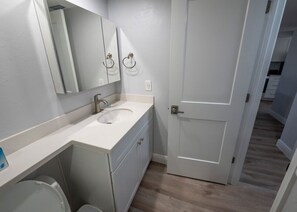 A bathroom with a white sink, mirror, and toilet. - Sanibel, Shell Island Beach Club, Oceanfront
Near Lighthouse (Sanibel)