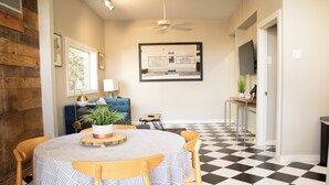 A dining area with a round table, chairs, and a blue sofa.