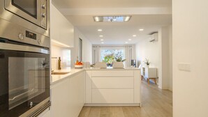 Una cucina moderna con elettrodomestici integrati, un'isola centrale e vista sull'area pranzo.