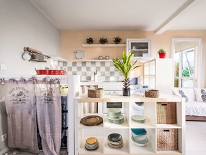 Een koelkast, een oven, kookgerei, borden en bestek