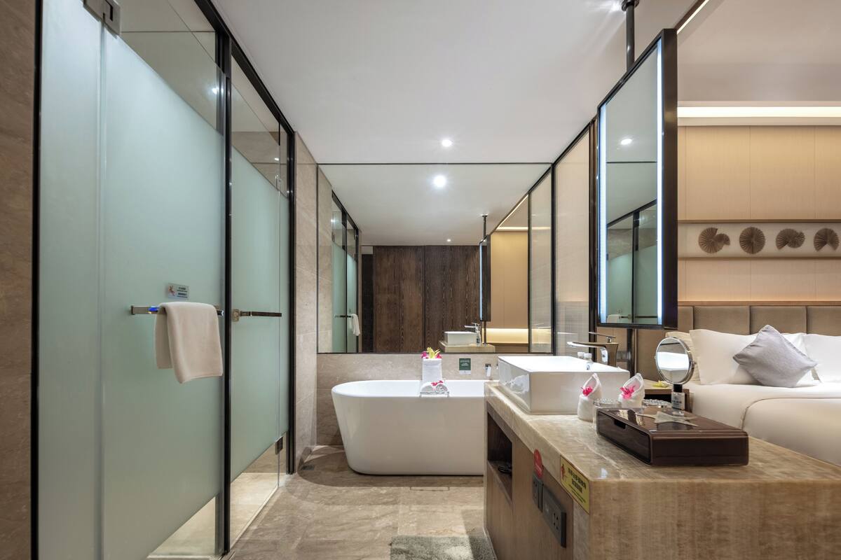 A modern bathroom with a freestanding bathtub, a vanity with a mirror, and a large mirror above the sink.