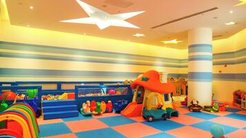 A children's play area with a slide, climbing steps, and a playhouse.