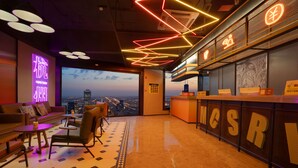 A modern hotel lobby with a city view, a reception desk, and a seating area with a patterned floor. - Mcsrh Hotel -Hangzhou West Lake (Hangzhou)