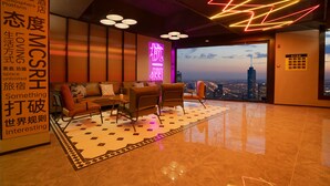 A modern hotel lobby with a seating area, a neon sign, and a view of the cityscape. - Mcsrh Hotel -Hangzhou West Lake (Hangzhou)