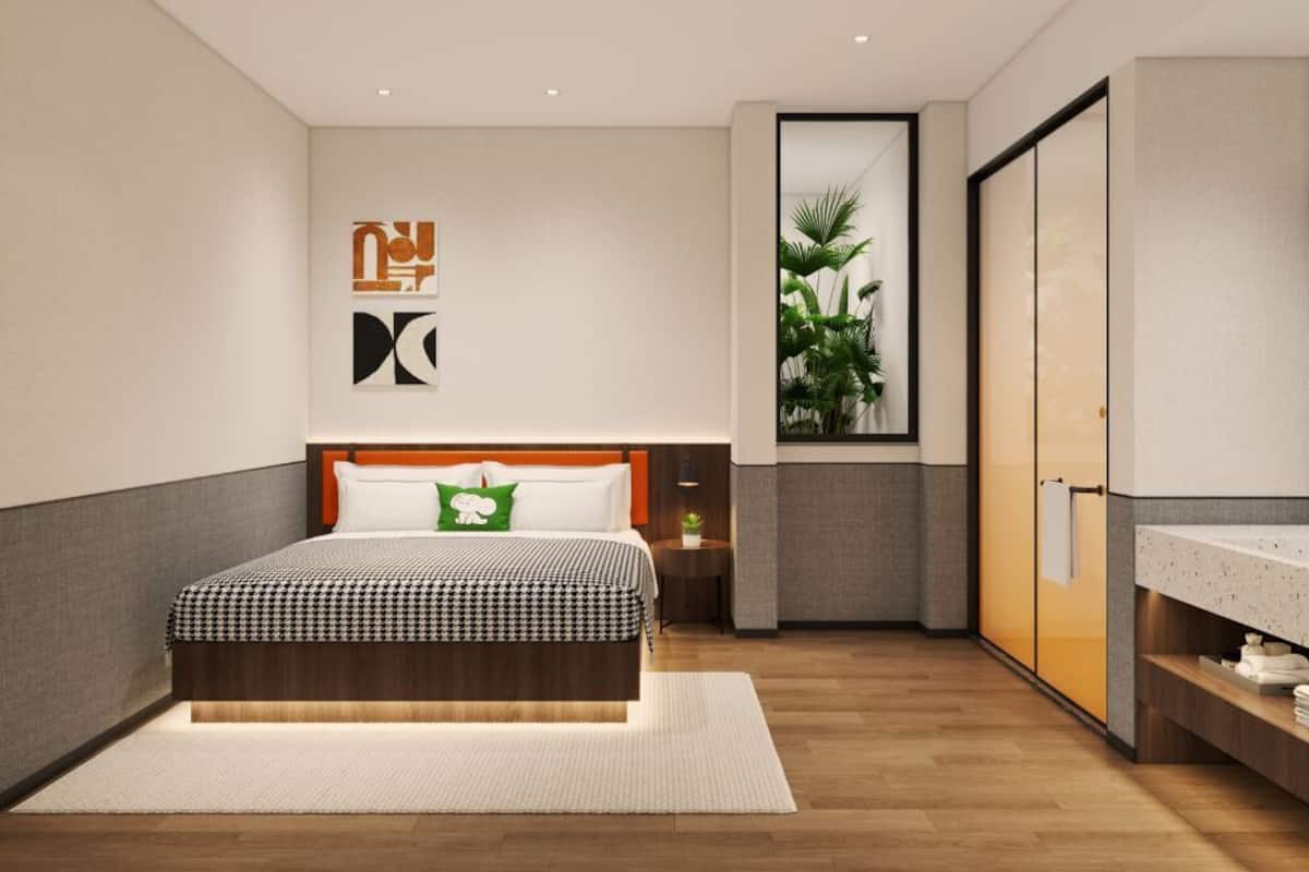 A modern bedroom with a large bed, a nightstand, a mirror, and a wardrobe.