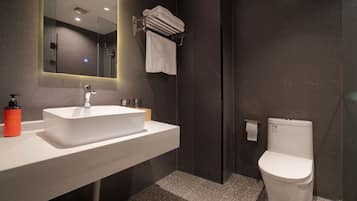 A modern bathroom with a white sink, a mirror, a towel rack, and a toilet.