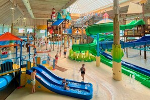 An indoor water park with multiple slides and play structures.