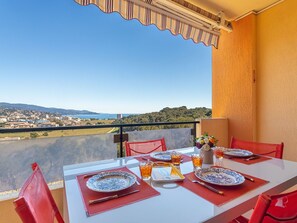 Un tavolo da balcone apparecchiato con piatti, bicchieri e posate, con vista sulla città e sulle colline.