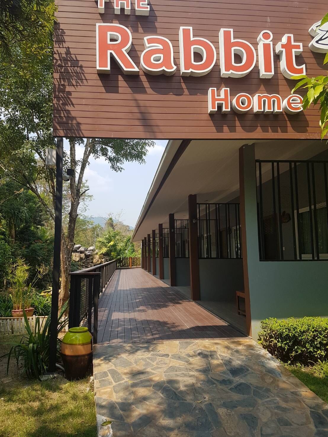 Een pad dat naar een gebouw leidt, met een bord waarop staat 'The Rabbit Home'.
