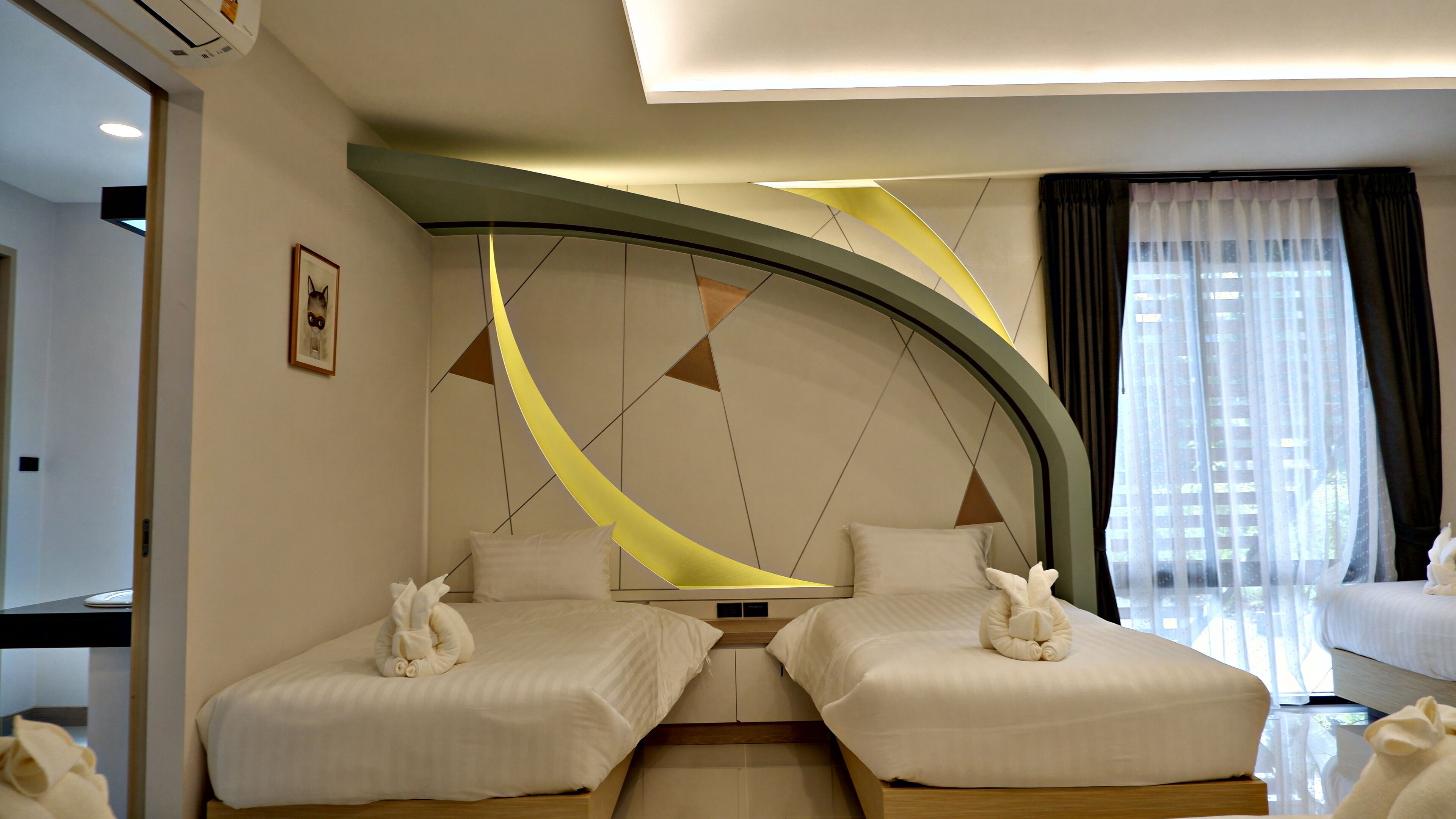 A hotel room with two beds, a modern design, a large window with curtains, and a framed picture on the wall.