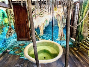A room with a mural, a wooden door, and a circular pool. - Alma Libre Hotel Tulum (Tulum)