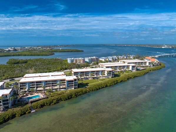 Un hotel costero con varias edificaciones, una piscina y un puerto deportivo.