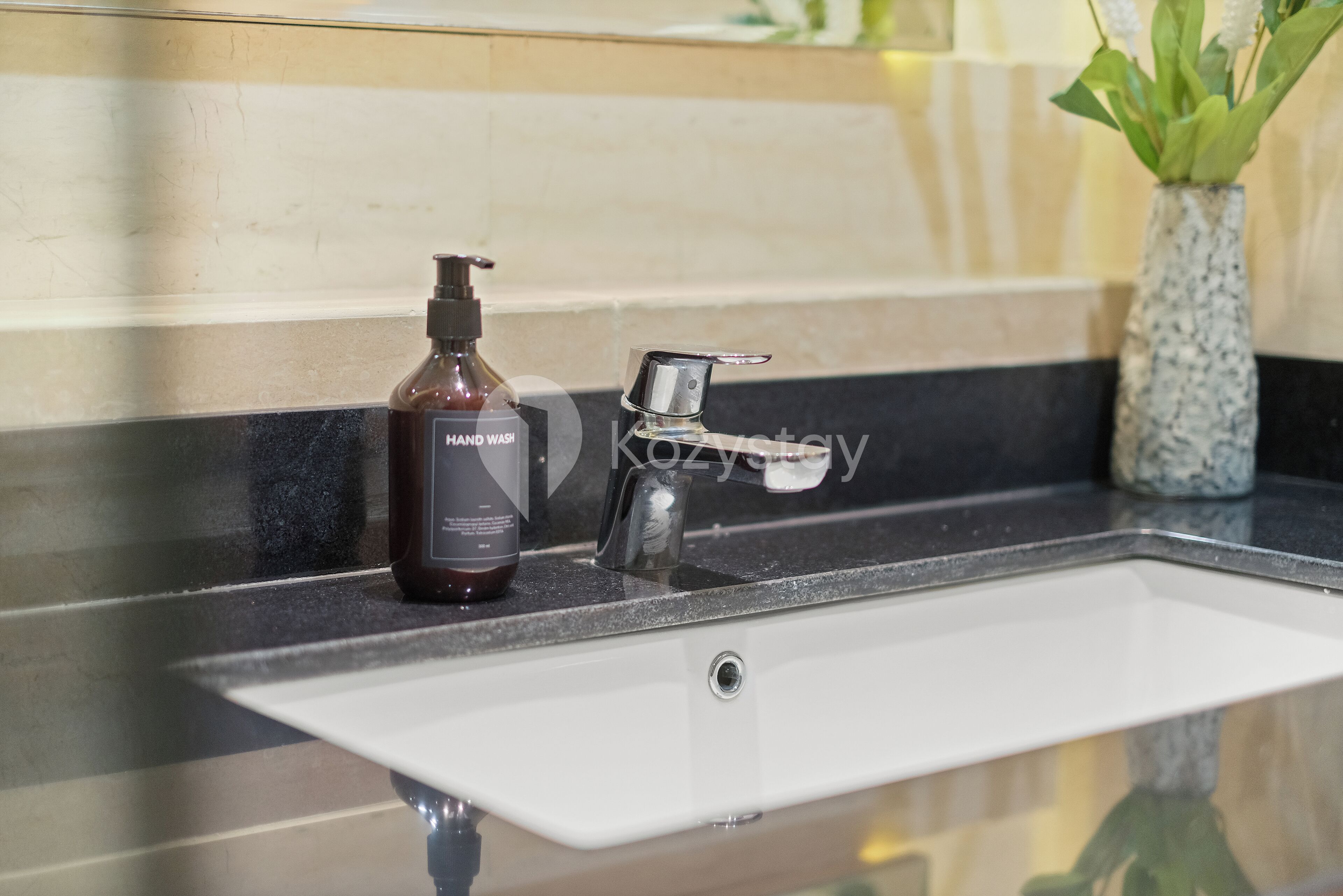 Un lavabo de salle de bain équipé d’un distributeur de savon liquide et d’un robinet.