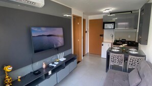A modern living room with a flat-screen TV, a sofa, and a small entertainment unit. - Flat vista Piscina e Lagoa 203c Bela bLP (Ipojuca)