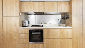 Una cocina moderna con armarios de madera, horno integrado, estufa y lavaplatos.