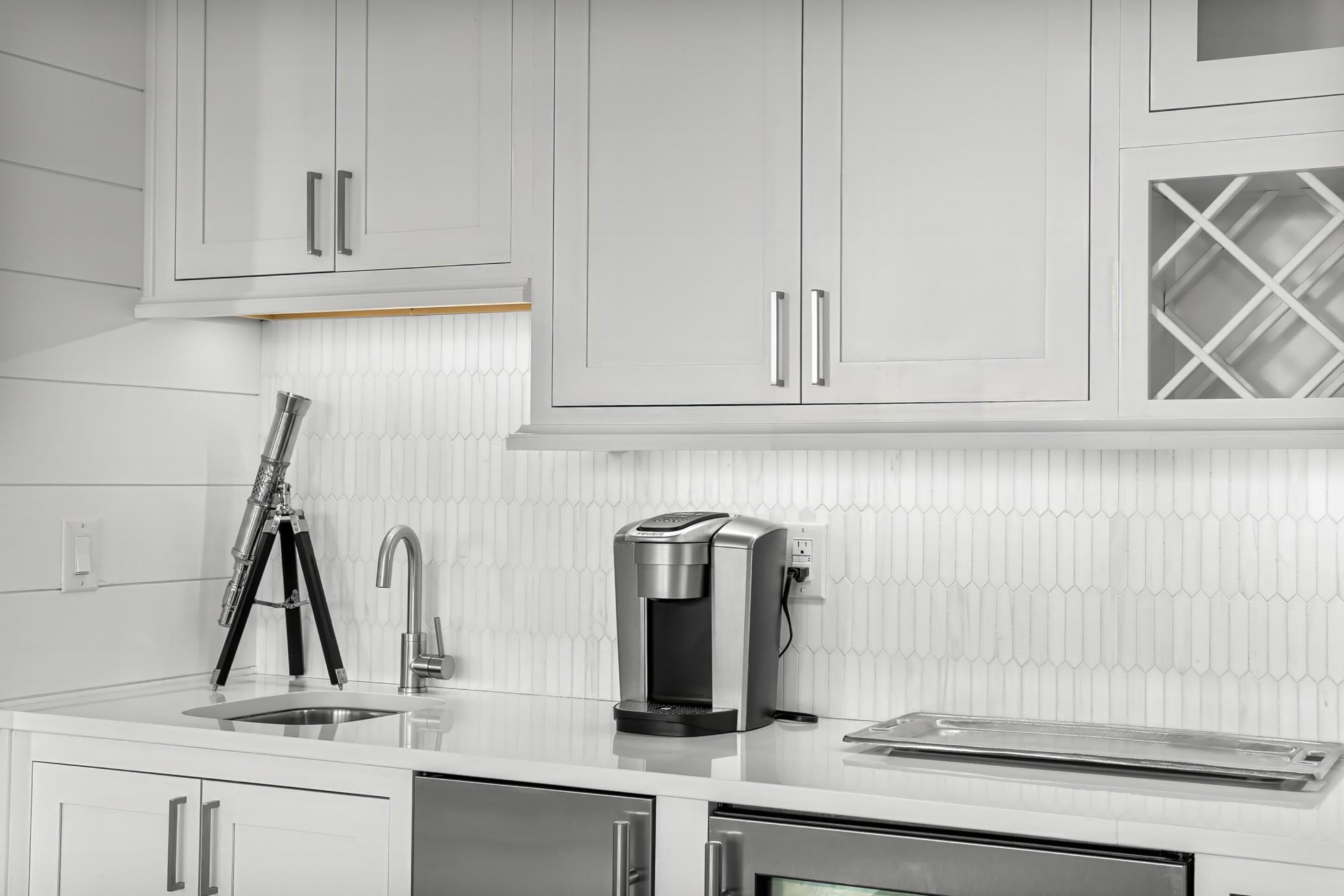 Een moderne keuken met witte kastjes, een koffiezetapparaat en een broodrooster.