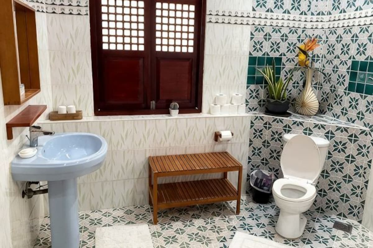 Un baño con lavamanos, inodoro y ventana.