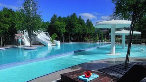 A swimming pool with a slide and a gazebo.