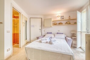 Un dormitorio con cama, mesita de noche, armario y estante decorado con objetos decorativos.