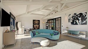 A modern living room with a curved sofa, a large Buddha statue, and a mirrored console table. - Villa Bayugita With Master Bedroom, Grimaud, France (Grimaud)