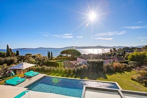 Un espace piscine offrant une vue sur la mer et les montagnes.