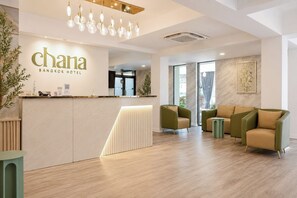 Uma área de recepção com design moderno, incluindo um balcão de atendimento, espaço para sentar e um candelabro.