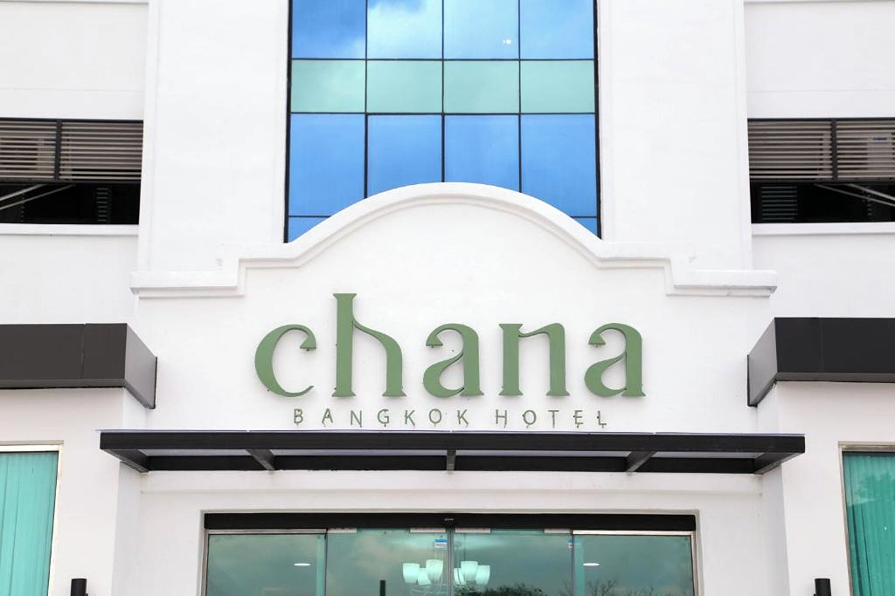 The facade of the Chana Bangkok Hotel with its name displayed prominently above the entrance.