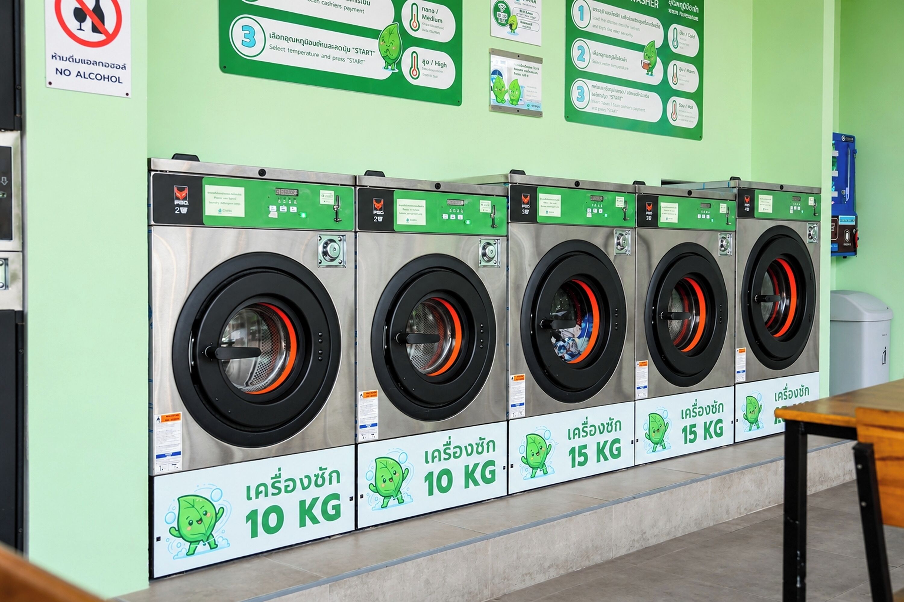 A row of front-loading washing machines with capacity labels of 10 KG and 15 KG.