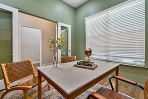 Un comedor con una mesa, sillas, un florero con plantas y un globo terráqueo sobre la mesa.