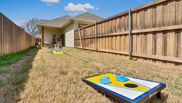 Un jardin avec un trampoline et une clôture en bois.