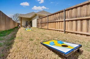 Un jardin avec un trampoline et une clôture en bois.