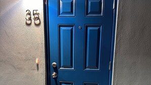 Una puerta azul con un felpudo que dice 'Welcome'.