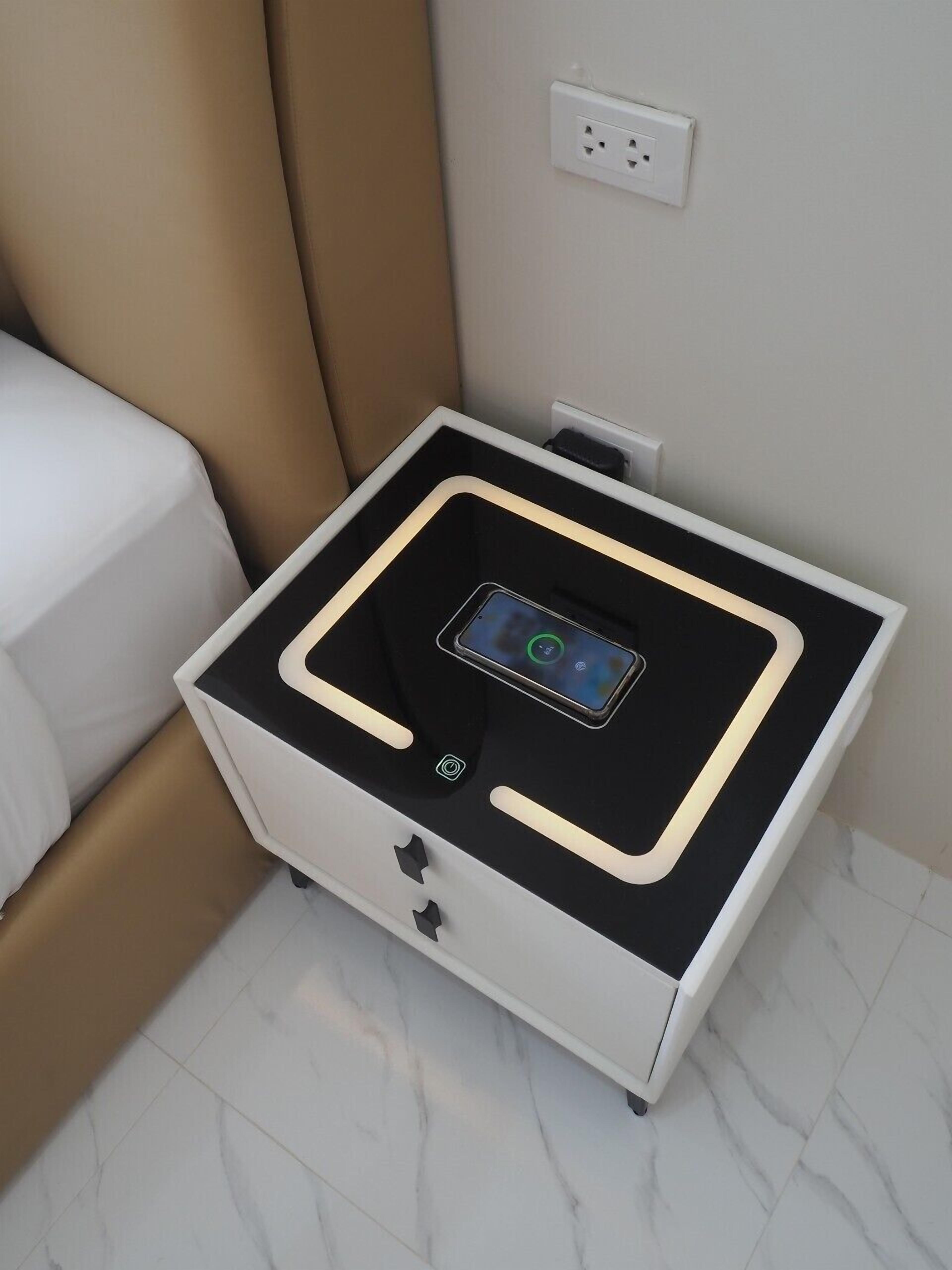 A modern bedside table with a built-in charging station and a smartphone dock.