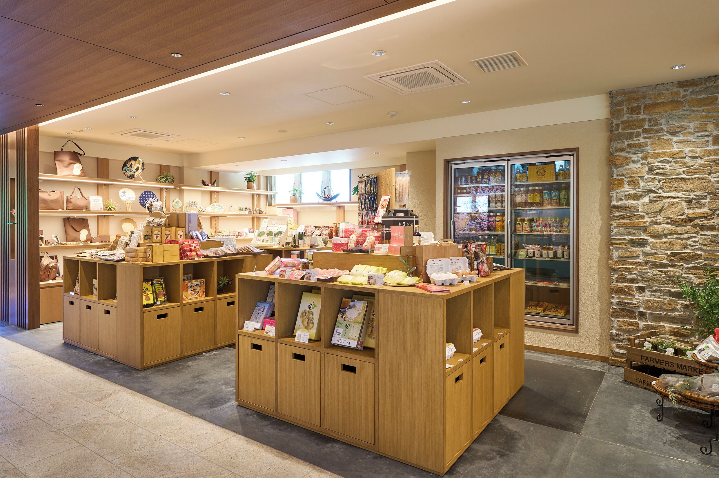 A store with wooden display units, a stone wall, and a refrigerated section.