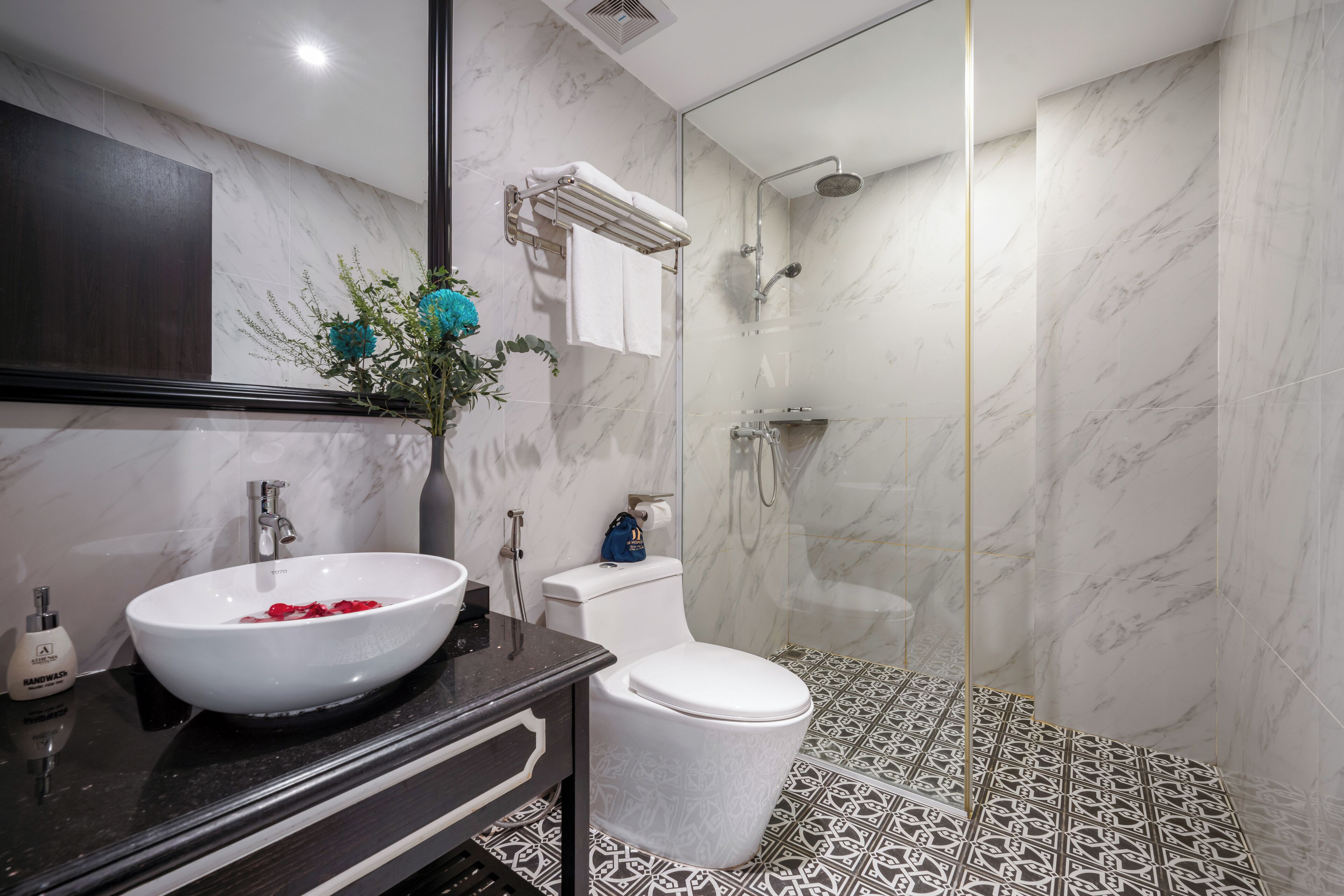 A modern bathroom with a white sink, toilet, and shower.
