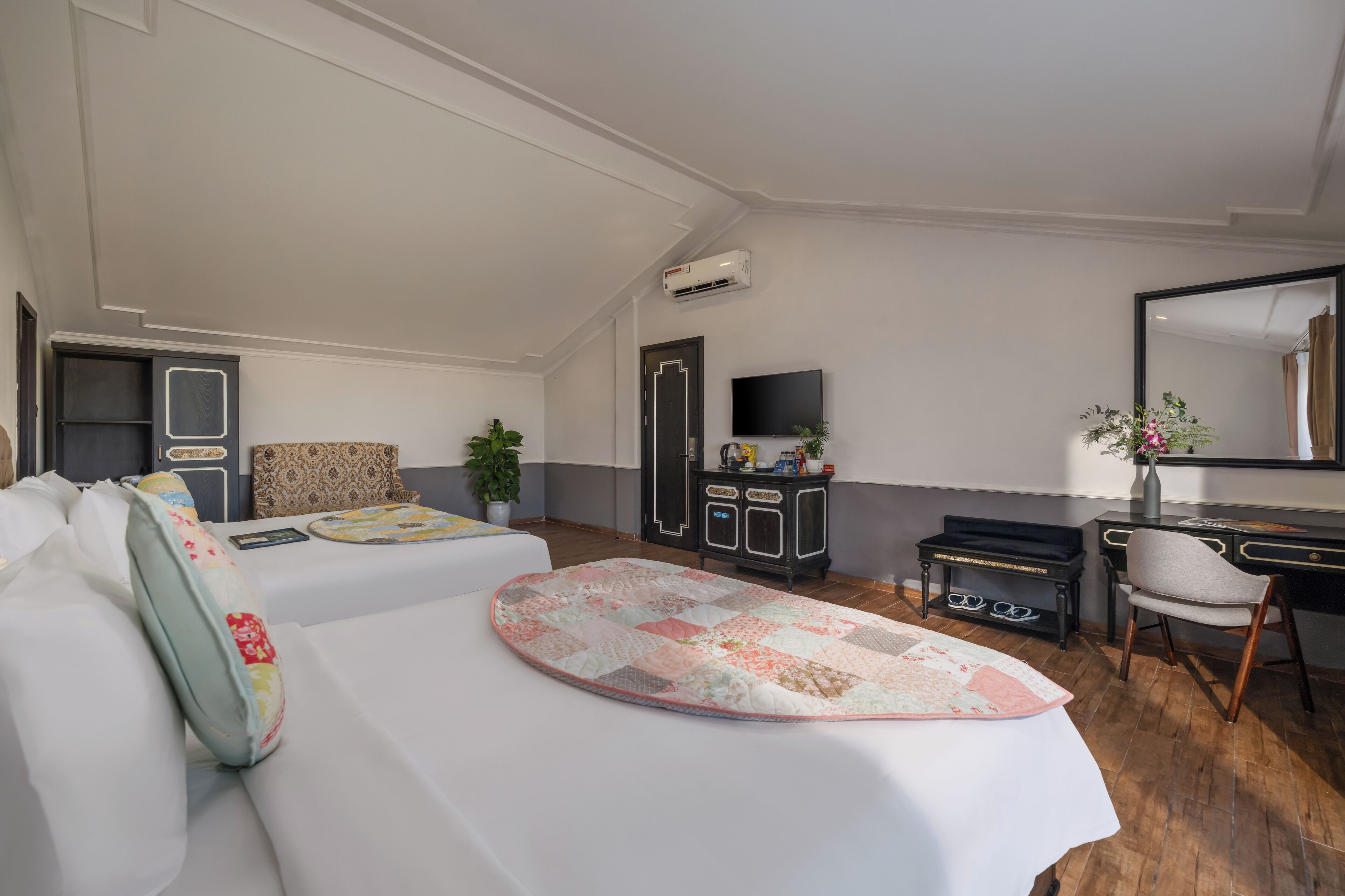A hotel room with a bed, a desk, a chair, a TV, and a wardrobe.